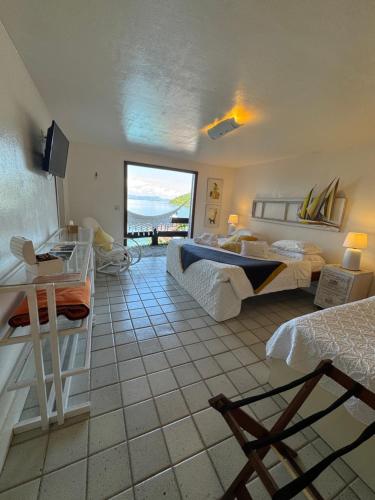 a bedroom with two beds and a view of the ocean at Pousada Casa do Bicho Preguiça in Angra dos Reis