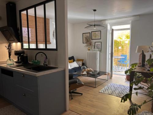 une cuisine avec un évier et un salon dans l'établissement Chez ROSE, à Bruyères