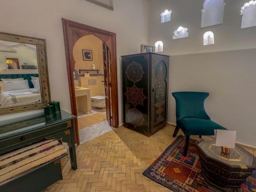 a room with a bedroom with a mirror and a chair at Riad Al-Qurtubi in Tangier