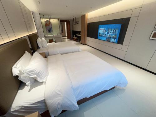 a bedroom with two beds and a flat screen tv at Zhongshan Jiayue Hotel in Zhongshan