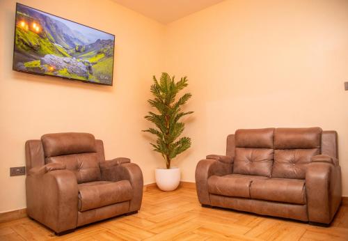 two brown chairs and a plant in a room at Skylark Hotel in Karatu