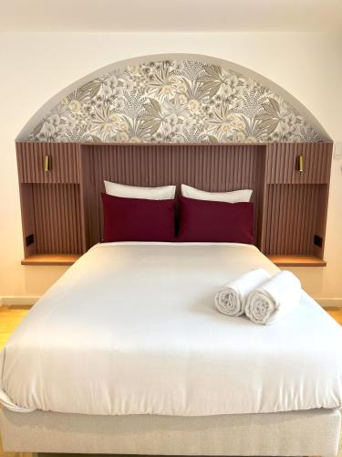 a bedroom with a large bed with two pillows at Villa Noellet - Clermont Ferrand in Aubière