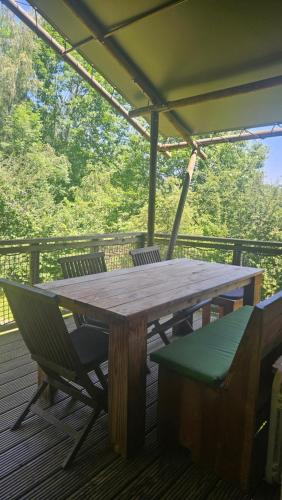 a wooden table and chairs on a deck at Camping LA SERRE in Aigues-Vives