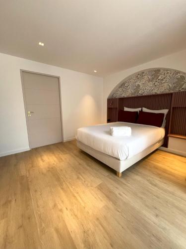 a bedroom with a large bed and a wooden floor at Villa Noellet - Clermont Ferrand in Aubière