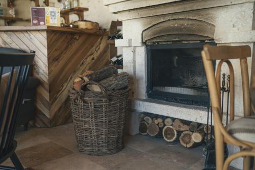 a fireplace with a basket of logs next to it at Vie Cappadocia - Adults Only in Nevsehir