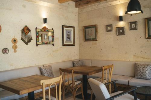 a restaurant with two wooden tables and chairs at Vie Cappadocia - Adults Only in Nevsehir