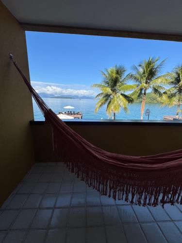 a hammock in a room with a view of the ocean at Pousada Casa do Bicho Preguiça in Angra dos Reis