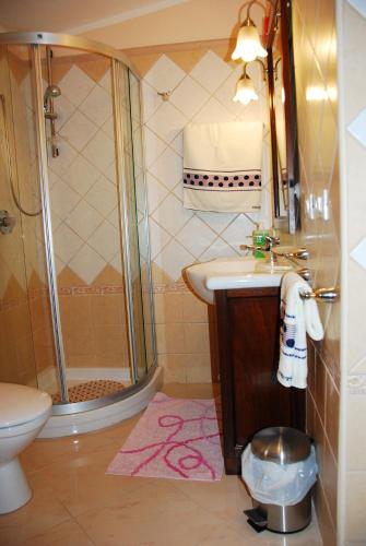 a bathroom with a shower and a sink and a toilet at Villa Lussu in Orosei