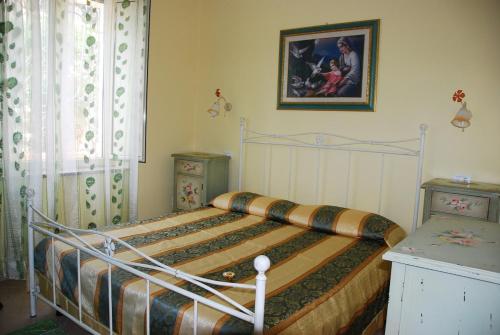 a bedroom with a bed and a picture on the wall at Villa Lussu in Orosei