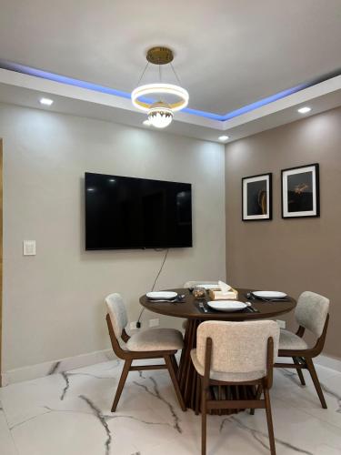 a dining room with a table and a flat screen tv at Santana Building in San Pedro de Macorís