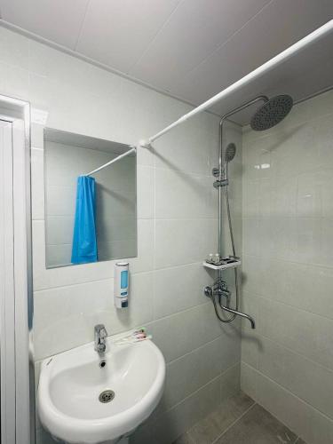 a bathroom with a sink and a shower with a mirror at Navruz Hostel in Samarkand