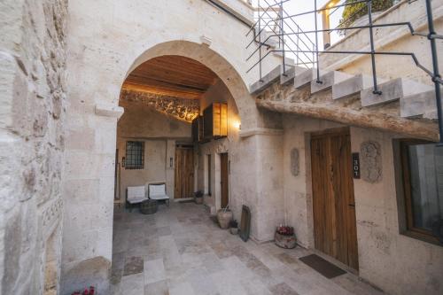 a hallway in an old building with an archway and stairs at Vie Cappadocia - Adults Only in Nevsehir