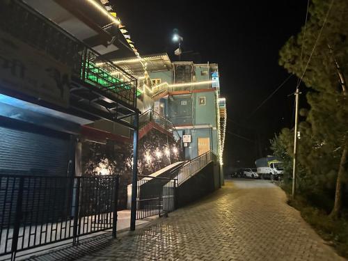 a building at night with lights on a street at Mountain View l 1BHK,2BHK,3BHK,4BHK,10BHK l Sitting Area Availbale by Night Sky in Kasauli