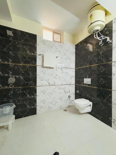 a bathroom with a toilet and a black and white wall at Mountain View l 1BHK,2BHK,3BHK,4BHK,10BHK l Sitting Area Availbale by Night Sky in Kasauli