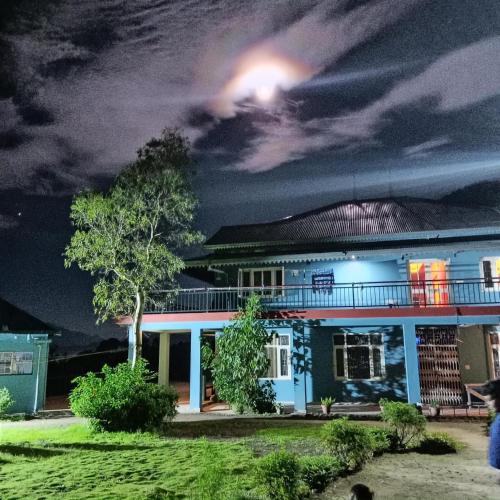 a blue house at night with a moon at Mountain View l 1BHK,2BHK,3BHK,4BHK,10BHK l Sitting Area Availbale by Night Sky in Kasauli