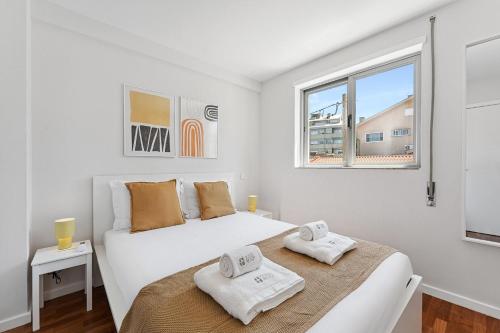 a white bedroom with a bed and a window at GuestReady - Fantastic family home in Salgueiros in Porto