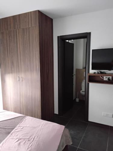 a bedroom with a bed and a flat screen tv at Apartmani Sutomore Tri Palme in Sutomore