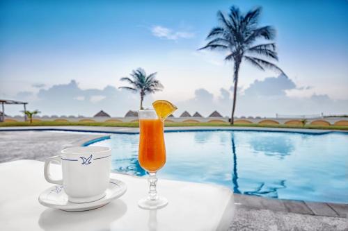 a drink and coffee on a table next to a pool at Club Maeva Miramar Tampico in Ciudad Madero