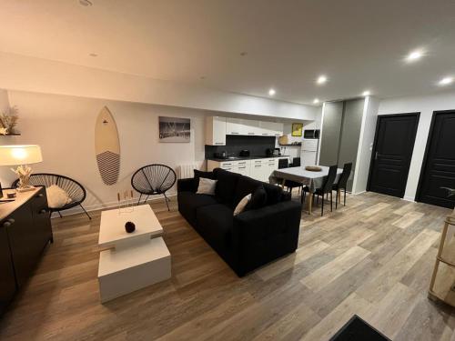 un salon avec un canapé et une table et une cuisine dans l'établissement La parenthèse au pied du lac, à Lacanau