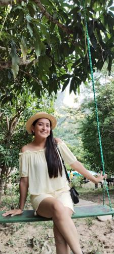 a woman in a hat sitting on a swing at Mirador Jungle El Macuti in Rurrenabaque