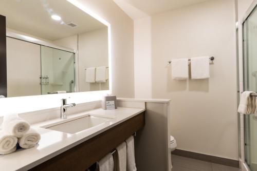 a white bathroom with a sink and a mirror at Holiday Inn Express & Suites - Edmonton SW – Windermere by IHG in Edmonton