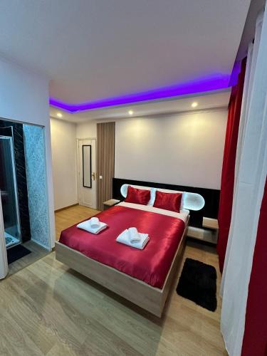 a bedroom with a red bed with two towels on it at Linda Flor in Barreiro
