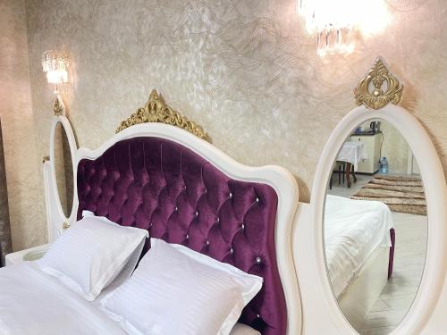 a bedroom with a bed with a purple headboard and a mirror at Museum Boutique Luxury GH in Sheki