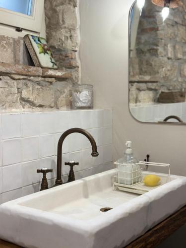 a white sink with a mirror and a sink at Nido di Gufi in Todi