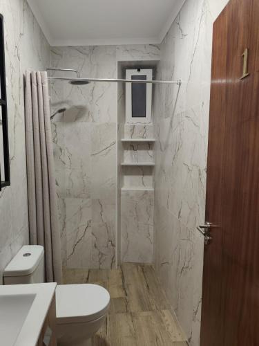 a white bathroom with a toilet and a sink at Simply House in Faro