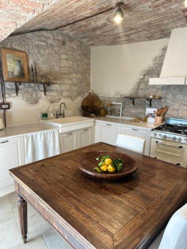 a kitchen with a wooden table with a bowl of fruit on it at Nido di Gufi in Todi