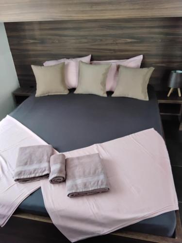 a large bed with white sheets and pillows at Apartmani Sutomore Tri Palme in Sutomore