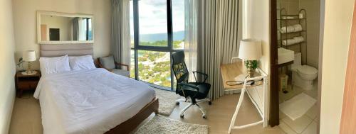 a hotel room with a bed and a desk and a window at 180 degree ocean view apartment in Punta Engaño