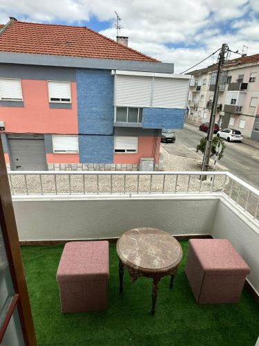 a patio with a table and two stools on a balcony at Linda Flor in Barreiro