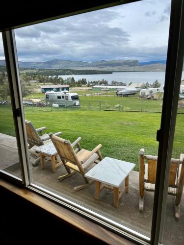 a window with two chairs and a table and a field at Lakeviewlanding in Big Arm