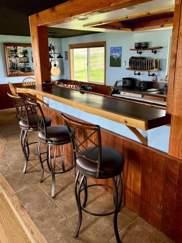a kitchen with a bar with chairs and a counter at Lakeviewlanding in Big Arm