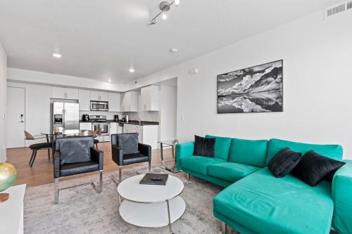 a living room with a green couch and a table at Modern Resort Styled 2BR Apt W Pool, Gym & Hot Tub in Salt Lake City