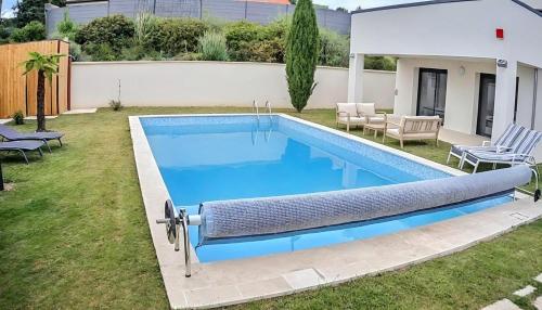 une piscine dans l'arrière-cour d'une maison dans l'établissement Villa 5 étoiles with swimming pool, sauna and balneo, à Bouleuse