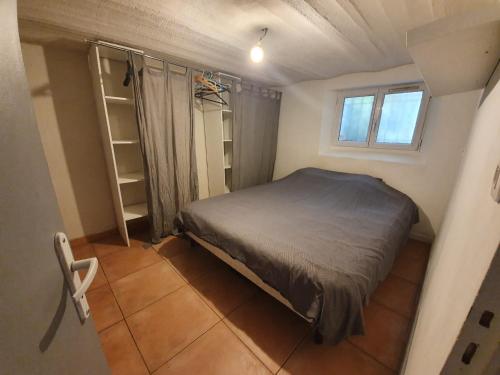 a small bedroom with a bed and a window at Belle maison meulière 135m2 in Livry-Gargan