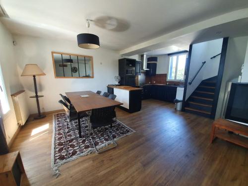 un salon avec une table et une télévision dans l'établissement Belle maison meulière 135m2, à Livry-Gargan