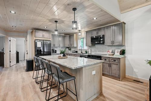 a kitchen with a large island with bar stools at 10-Acre Property with Fire Pit and Grill in Arkdale! in Arkdale