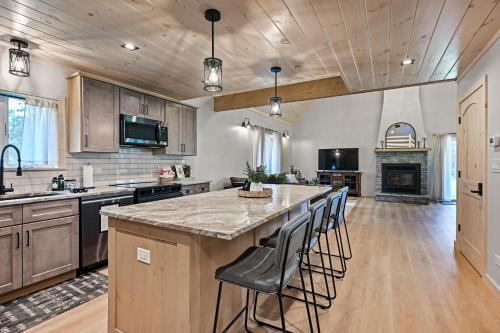 a kitchen with a large island with bar stools at 10-Acre Property with Fire Pit and Grill in Arkdale! in Arkdale
