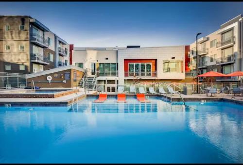 a large swimming pool with blue water in front of buildings at Modern Resort Styled 2BR Apt W Pool, Gym & Hot Tub in Salt Lake City