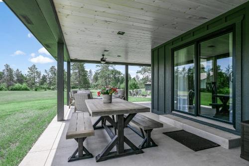 a patio with a picnic table and benches on a house at 10-Acre Property with Fire Pit and Grill in Arkdale! in Arkdale