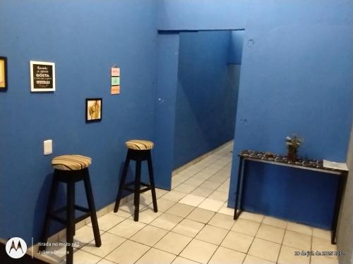 a room with two stools and a blue wall at Duque HOSTEL in Belém