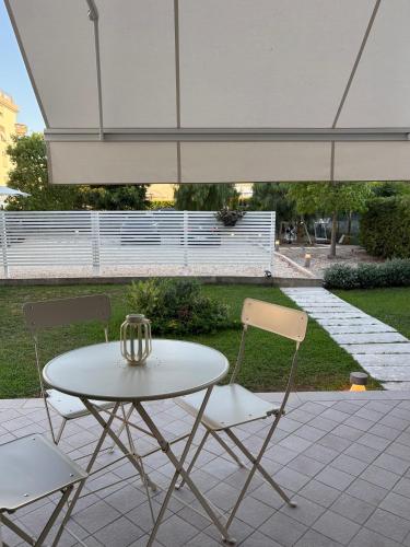 a white table and two chairs with a table and an umbrella at Casa Mar - B&B - in Terracina