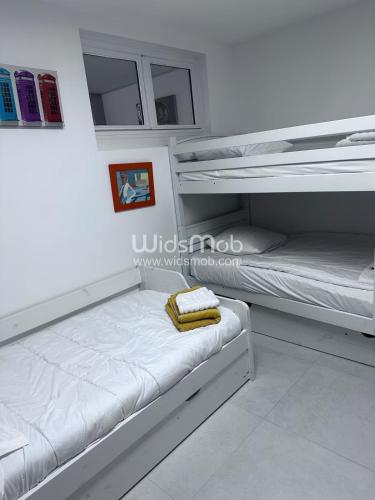 Ce lit se trouve dans un dortoir doté de 2 lits superposés et de murs blancs. dans l'établissement La plage d'Ugo, à Mauguio