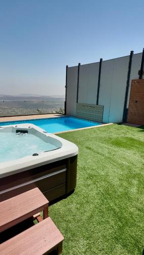 a hot tub sitting on the grass next to a building at Galilee Hills - Resort & Suites in Maghār