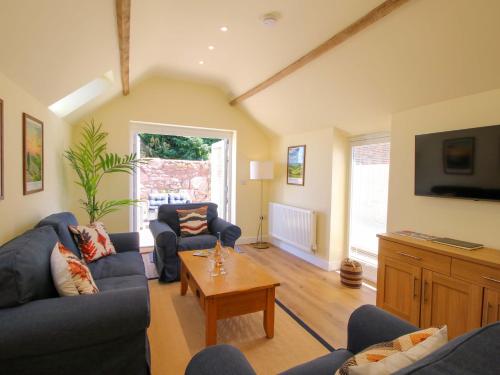 a living room with two couches and a coffee table at The Old Piggery in Shifnal