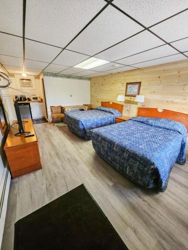 una camera d'albergo con due letti e una televisione di Katahdin Valley Motel 
