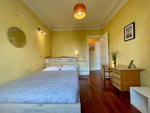 une chambre avec un grand lit et un bureau dans l'établissement Appartement Convention 5 Paris, à Paris